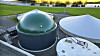 Kuppelformede tanker ved et GreenFarm-anlegg, omgitt av grønne jorder.